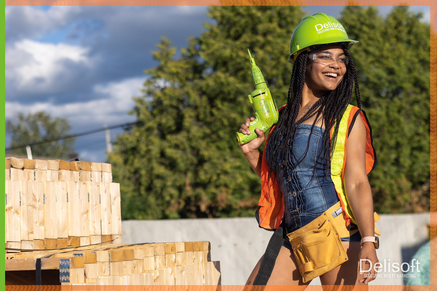 Femme portant une veste orange vif devant un équipement de construction, tenant une pancarte de Delisoft indiquant 'Création de site web dans le domaine de la construction' avec des avantages listés et une offre de soumission gratuite.